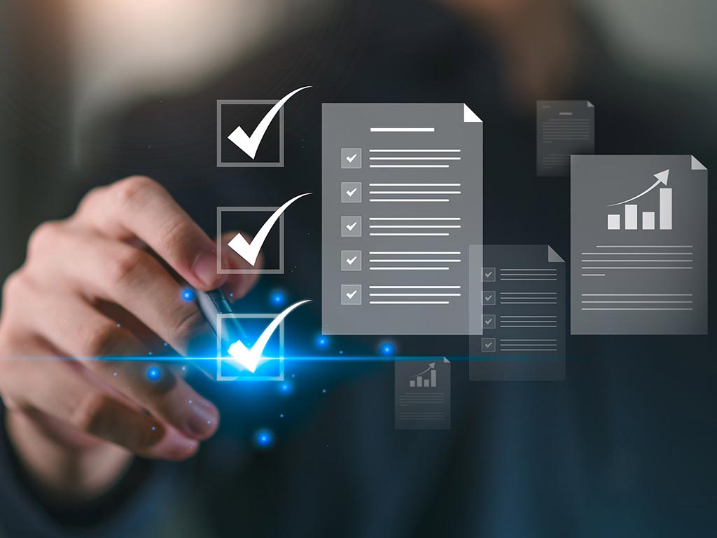Hand touching digital checkboxes with floating icons of documents and graphs, symbolizing task completion, data, and business analytics.